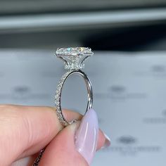 a person holding a diamond ring in their hand