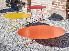 three tables sitting next to each other on gravel