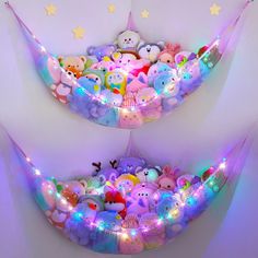 there are many stuffed animals in the bed with lights around them and on the wall