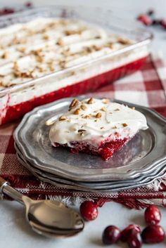 a piece of cake sitting on top of a glass plate next to cranberries