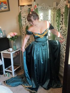 a woman in a green dress looking at herself in the mirror with her hands on her hips