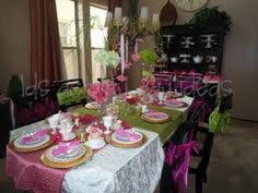 the table is set with pink and green plates