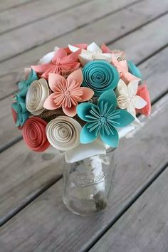 a vase filled with paper flowers sitting on top of a wooden table next to an instagram page