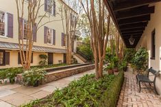 an outdoor patio area with steps leading up to the front door and trees lining the walkway