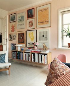 a living room filled with furniture and lots of pictures on the wall above it's bookshelf