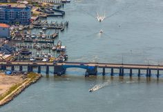 an aerial view of a bridge over water with boats in the water and buildings on either side