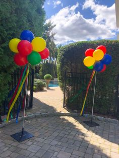 some balloons and streamers are in front of a gated entrance to a house