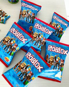 five packs of robbox candy sitting on top of a white table next to other snacks