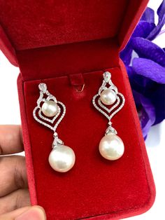 We are presenting you a HUGE pair of CHANDELIER, Genuine, PURE White South Sea Pearls, extremely FINE A+, LUSTROUS and Rare! Accenting the 4 pearls are 136 pieces of E/VS Natural diamonds, weighting a total of 1.62 carats. Set in fabulously designed 18K solid white gold earrings ONLY ONE ITEM AVAILABLE!! NO DUPLICATES!! WHAT YOU SEE IN THE PICTURES IS WHAT YOU WILL GET SOLIDLY HANDCRAFTED EARRINGS! SUGGESTED RETAIL VALUE: $10,880 PEARLS: Size: Bottom Pair 14 x 15 mm, Top Pair 11 mm. Shape: Round Luxury Pearl White Dangle Pearl Earrings, White Drop Jewelry With Elegant Design, Luxury Drop Bridal Earrings With Elegant Design, Luxury Drop Earrings Bridal With Elegant Design, Luxury Drop Earrings With Elegant Design For Bridal, Luxury Drop Earrings With Elegant Design, White Gold Pear-shaped Bridal Earrings, Elegant Pear-shaped White Jewelry, Luxury White Pearl Earrings In Sterling Silver