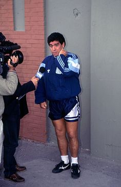 a man in shorts is being interviewed by reporters