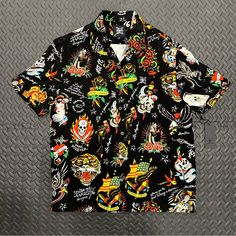 Stand Out From The Crowd With This Ed Hardy Button-Up Shirt. Featuring A Striking Graphic Print Of Skulls, Birds And Tattoos, This Shirt Is Perfect For Any Occasion - From Casual Hangouts To Workwear. The Collared Neckline And Short Sleeves With Button Closure Make It Ideal For Summer, While The Viscose Material Ensures It's Lightweight And Easy To Care For. Add Some Personality To Your Wardrobe With This Designer Shirt. 100% Authentic. Size Medium. 100% Viscose. Made In China. In-Hand Ready To Black Shirt With Button Closure For Streetwear, Black Button Closure Shirt For Streetwear, Black Retro Shirt With Camp Collar, Black Camp Shirt With Johnny Collar, Streetwear Camp Shirt With Button Closure And Camp Collar, Streetwear Camp Shirt With Button Closure, Black Camp Collar Top For Streetwear, Black Buttoned Shirt For Summer, Black Summer Shirt With Buttons