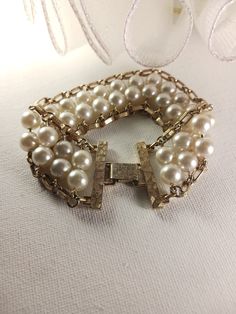 This vintage Pearl Flattery bracelet features faux pearl and gold tone chain link with a snap lock clasp. Sarah Coventry signed. This bracelet is in good vintage condition. Sarah Coventry signed Faux Pearl and Gold Tone Chain Link Bracelet, Vintage Wedding Jewelry, Bridal Reflections, SFV138   <-- BACK to my shop and please remember to admire my shop for further updates: https://www.etsy.com/shop/silverfeathervintage Thank you for your interest in Silver Feather Vintage! * Please carefully revie Vintage White Pearl Bracelet For Anniversary, Vintage Pearl Bracelet For Formal Occasions, Vintage Pearl Bracelet For Wedding, Vintage Gold Bracelet With Chain, Vintage Pearl Bracelet For Anniversary, Elegant Gold Bracelets For Vintage Events, Formal Adjustable Pearl Chain Bracelet, Vintage Metal Bracelets For Weddings, Classic Metal Pearl Bracelet For Formal Occasions