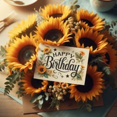 a birthday card surrounded by sunflowers on top of a table with silverware