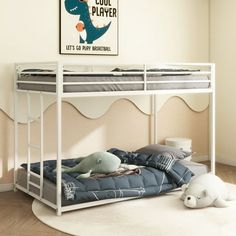 a white bunk bed sitting on top of a hard wood floor next to a wall