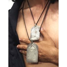 a man with no shirt wearing a necklace that has a silver locke on it's chest