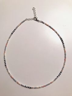 This dainty Seed Bead Choker Necklace is made with pretty multi-colored glass seed beads. The tiny seed beads are strung on beading wire & finished with a silver plated lobster style clasp with a 2 inch extension chain, to allow for personal size adjustments. These necklaces are perfect for everyday wear. Enjoy a simple, boho /chic look with a single strand or layer them with some of our other chokers. * Custom hand-made to order * Glass seed bead size 11/0 * Lobster Clasp closure * Stainles Heishi Beaded Necklaces For Jewelry Making, Czech Glass Beaded Chain For Jewelry Making, Silver Heishi Beaded Bracelets With Tiny Beads, Silver Heishi Bead Bracelet With Tiny Beads, Adjustable Silver Heishi Beads Necklace, Pink Beaded Czech Glass Necklace, Silver Beaded Chain Necklace With Czech Glass, Dainty Multicolor Necklace With Spacer Beads, Dainty Multicolor Necklaces With Spacer Beads