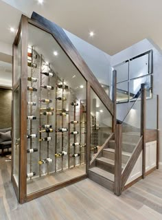 a wine cellar in the middle of a room with stairs leading up to an open door