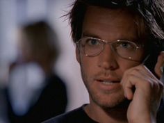 a man with glasses talking on a cell phone