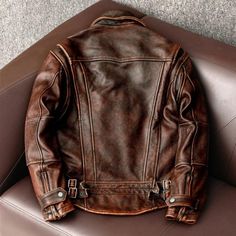 Description: Step into timeless style with this vintage brown cowhide leather faux jacket. Inspired by classic biker aesthetics, this slim-fit coat offers a rugged yet refined look. Crafted with high-quality faux leather, this jacket boasts a rich, distressed finish that adds a touch of authenticity. Features:  * Premium Faux Leather: Durable and soft to the touch, the faux leather construction ensures long-lasting wear.  * Vintage Brown Finish: The distressed brown hue creates a weathered, vintage appearance.  * Slim Fit Silhouette: Flattering and modern, the slim fit accentuates your physique.  * Asian Style: Inspired by Asian fashion trends, this jacket offers a unique and stylish look.  * Biker-Inspired Details: The classic biker jacket design features buttoned cuffs, a collar with buc Male Biker, Biker Clothing, Men Leather Jacket, Vintage Cafe Racer, Leather Jacket Vintage, 90s Fashion Men, Biker Outfit, Brown Cowhide, Coat Men