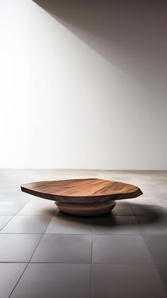 a wooden table sitting on top of a tile floor next to a white wall in an empty room