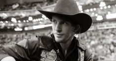 a black and white photo of a man wearing a cowboy hat at a baseball game