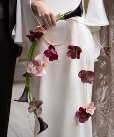 the bride and groom are holding their bouquets with purple flowers on each side of them