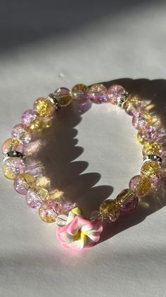 This bracelet has a 6.5 to 7in circumference (depends on what base you want.) The stones used are glass with your choice of silver or gold spacers lined with cubic zirconia, or  just faux pearl by its self. The band is made of elastic. the flowers are made of clay. there's an option under personalization to leave me a note of what you do or do not want, otherwise I will pick the flower at random. (very limited color options so what you want may not be available). Disclaimer: This product contains small parts that may pose a choking hazard for young children. Please exercise caution and supervise its use around children. Adjustable Glass Jewelry For Parties, Adjustable Flower Beaded Bracelets For Parties, Adjustable Crystal Flower Bracelet For Party, Adjustable Flower Crystal Bracelet For Party, Adjustable Flower Shaped Crystal Bracelet For Party, Adjustable Flower-shaped Crystal Bracelet For Party, Multicolor Flower Crystal Bracelet Gift, Adjustable Pink Glass Bracelets, Adjustable Pink Bracelets