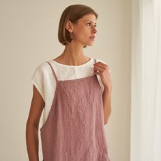 "Haven - everyday pinafore dress with endless styling possibilities. FEATURES: * comfy pockets * loose cut * dress length is 90 cm / 35.4\" (size S) * 100 % natural, certified linen fabric * dyed and washed in small batches * natural cotton yarns * biodegradable button frontline * handmade at a small studio in Europe COLORS: Dyed and washed in small batches, so the color will be unique and superb quality to each piece. Please check the color options on the side menu. SIZE GUIDE / BODY MEASUREMEN Essential Clothing Pieces, Linen Pinafore Dress, Japanese Style Apron, Pale Dogwood, Linen Apron Dress, Linen Pinafore, Linen Wrap Dress, Linen Sundress, Natural Linen Fabric