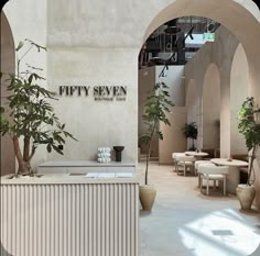 the interior of a modern restaurant with tables and plants in vases on the counter