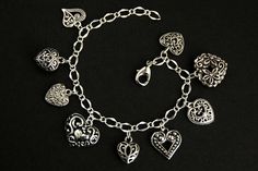 A collection of silver filigree-style heart charms have been dispersed around a shimmering silver plated bracelet chain in this handmade charm bracelet. This heart charm bracelet is then completed with a lobster clasp and a 1/2 inch of chain at the end for adjustable sizing. Charms in this bracelet include nine assorted heart charms in various decorative filigree designs. ● Sizing ● To determine your bracelet size, do a snug measurement of your wrist's circumference, then add 1/2 an inch. 6 to 6 Bracelet Fancy, Hearts Bracelet, Handmade Charm Bracelets, Filigree Heart, Bracelet Heart, Silver Plated Bracelet, Filigree Design, Handmade Charms, Bracelet Handmade