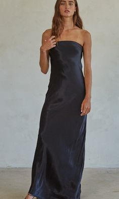 a woman wearing a black strapless dress