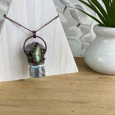 Fun and trendy Bohemian Style Gemstone Bottle Necklace with an accent stone is a unique and stylish piece of jewelry that combines the beauty of gemstones with a bohemian-inspired design. The necklace features a small bottle-shaped pendant, often made of glass, that is filled with natural gemstones of Amethyst, Labradorite, Jasper or Tiger's Eye. The accent stone is a larger and more striking stone that is set in a prominent position on the necklace, such as the top of the bottle pendant. Bohemi Adjustable Gemstone Jewelry, Adjustable Gemstone Amulet Jewelry, Healing Amulet Jewelry With Natural Stones, Bohemian Gemstone Crystals For Gifts, Unique Raw Stone Crystal Necklace For Jewelry Making, Round Pendant With Natural Stones For Healing, Unique Natural Stones Crystals For Gifts, Unique Natural Stones Crystals As Gifts, Unique Mineral Crystal Jewelry For Meditation