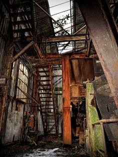 an old run down building with lots of rust on the floor and walls, including stairs