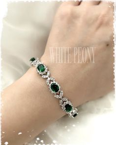 "Vintage Art Deco - Gatsby - Downton Abbey inspired emerald green crystal flower & leaf tennis bracelet : \"MAIA\" by ©White Peony by KC. This beautiful bracelet is made of sparkling AAA-quality emerald green and clear Cubic Zirconia (zircon, CZ) / rhodium plated components. Please note that product colors in photos may appear slightly different on various computer monitors/smart phones/tablets. Contact my shop if any additional photos are needed. Measures approx : photo shows 7 1/2\" (19cm) Elegant Silver Tennis Bracelet With Emeralds, Elegant Silver Emerald Tennis Bracelet, Green Emerald Bracelets For Party, Elegant Green Crystal Bracelets, Adjustable Green Jewelry For Wedding, Emerald Tennis Bracelet With 17 Jewels For Wedding, Green Jeweled Wedding Bracelets, Elegant Emerald Tennis Bracelet For Wedding, Silver Emerald Bracelets For Weddings