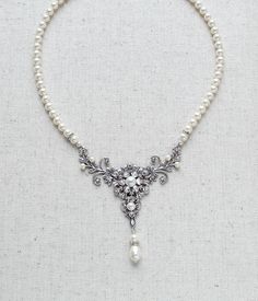 Pearl Bridal necklace is created with gorgeous antique silver filigrees in which I placed clear crystals and Crystal ivory pearls. Finished with matching Crystal ivory pearls. It is a beautiful piece, very detailed. Necklace measures 16 inches and extends to 18 inches. Size of silver center is 3-1/2 inches wide and 3 inches long to bottom of pearl drop. PLEASE ALLOW APPROX 2 WEEKS FOR COMPLETION This is an original design by © Treasures by Agnes Elegant Silver Pearl Necklace With Intricate Design, Elegant Antique Silver Jewelry For Wedding, Vintage Bridal Necklace With Pearl Drop, Vintage Bridal Pearl Necklace With Pearl Drop, Classic Silver Necklace For Mother Of The Bride, White Victorian Pearl Necklace, Elegant Bridal Necklace With Intricate Design In White, Silver Pearl Necklace With Intricate Design, Elegant White Bridal Necklace With Intricate Design