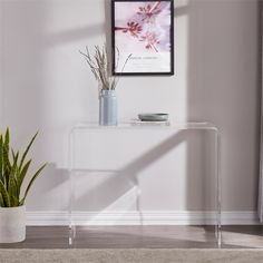 a clear console table with a plant on top