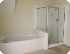 an empty bathroom with a tub and shower