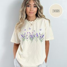 Lavender Wildflowers Comfort Colors® T-Shirt, Summer Wildflowers Tee Shirt, Lavender Shirt, Summer Wildflowers Shirt Gift, Lavender Gift Tee. Orders are processed within 24 hours and shipped out within 2 to 5 business days. What you receive: Comfort Colors® Adult Unisex Crewneck T-shirt Color Choices: Ivory White Pepper Orchid Sizes: Unisex adult sizing use size chart as a guide. These shirts are fitted and run true to size. If you prefer a loose fit go one size larger. If you want an oversized Lavender Floral Print Cotton Top, Lavender Cotton Tops With Floral Print, Purple Floral Embroidered Crew Neck Top, Purple Crew Neck Top With Floral Embroidery, Lavender Relaxed Fit T-shirt For Spring, Lavender Graphic Print Crew Neck Top, Summer Lavender Tops With Graphic Print, Lavender Crew Neck Top With Graphic Print, Lavender Graphic Print Tops For Summer