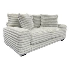 a white couch with pillows stacked on it's back and the arms folded down