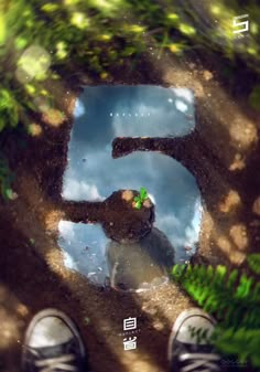 the reflection of a person standing in front of a puddle with grass and trees on it