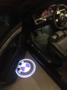 the interior of a car with an illuminated bmw emblem