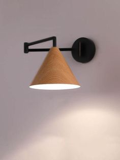 a wall light with a wooden shade hanging from it's side on the wall