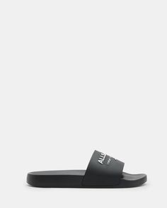 Moulded from rubber, our Underground Slides are essential for chilled out summer styling. Our iconic signature features across the strap. From London to Tokyo - that's the bestselling Underground logo. An ideal casual staple for hot days, or even team them with matching socks - it's a look. If you are between sizes, we recommend sizing up Slides Round toe Moulded silhouette Slip on AllSaints Underground logo Casual Black Slides With Logo, Black Slides With Logo For Summer, Black Logo Slides For Summer, Modern Slides For Spring Streetwear, Summer Beach Slides With Logo, Sporty Slides For Summer Swimming, Sporty Slides For Swimming In Summer, Summer Sports Slides, Casual Logo Slides For Spring