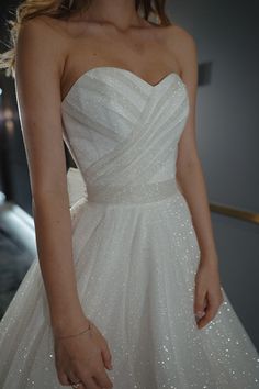 a woman in a white wedding dress holding her hand out