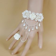 This an absolutely stunning bracelet very elegant and sophisticated. This bracelet is one size fits all with adjustable chains for the cuff area and an adjustable ring to fit all sizes. The cuff area is made with white lace and decorated with white pearls and a gorgeous white polymer clay rose and then to connect with the ring is a chain with tear drop pearls and to match the bracelet is the same white rose polymer clay. Please take a look at my shop I have other bracelet you might love! a large Delicate White Adjustable Jewelry, Elegant White Pearl Bracelet With Adjustable Chain, White Pearl Bracelet With Adjustable Chain, Adjustable White Bracelets For Wedding, Delicate White Jewelry For Party, White Pearl Bracelets With Adjustable Chain, Adjustable Cream Jewelry For Parties, White Adjustable Party Jewelry, Adjustable White Party Jewelry