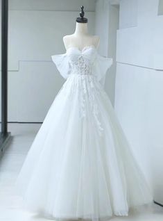 a white wedding dress on display in a room