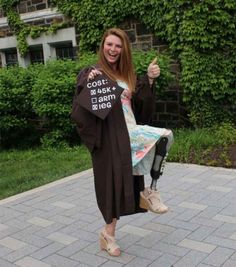 a woman in graduation gown giving the thumbs up with her thumb up and texting how to nail graduation