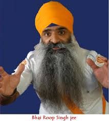 a man with a long beard wearing an orange turban and holding his hands out