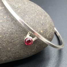 "I designed this simple, elegant and delicate sterling silver bracelet (available in Garnet or Sapphire) for women. in honor of mothers, and grandmothers and sisters, and girlfriends, and wives; in honor of women everywhere! I decided to designed a select number of pieces for women. Don't worry. I still specialize in Jewlery for Men. These are special limited designs for her. More stones varieties coming soon! I hand forged this bracelet in my home studio in Austin, TX. It's made of Sterling sil Modern Garnet Jewelry As A Gift, Modern Garnet Jewelry For Gift, Minimalist Sterling Silver Hallmarked Bracelet As Gift, Modern Sterling Silver Bracelet With Gemstone, Elegant Sterling Silver Bracelet With Birthstone, Mens Onyx Bracelet, Jewelry Sapphire, Garnet Bracelet, Garnet Jewelry