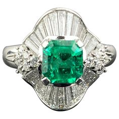 A classic, art-deco 1.18 carat Colombian Emerald and 1.34 carat Diamond baguette ring, set in platinum. The center stone has an ideal vivid green color, and a great shine/luster to it. The Emerald is transparent, and is of a very high quality. The ring is currently sized at US6, can be resized. Please feel free to message us for more information. We provide free shipping, and accept returns. Art Deco Emerald Ring With Baguette Cut Center Stone, Classic Green Emerald Ring With Baguette Diamonds, Gia Certified Green Emerald Art Deco Ring, Art Deco Emerald Ring In Baguette Cut White Gold, Art Deco Green Ring, Gia Certified, Art Deco Green Ring Gia Certified, Green Emerald-cut Art Deco Diamond Ring, Art Deco Green Emerald Cut Diamond Ring, Classic Green Diamond Ring With Baguette Diamonds